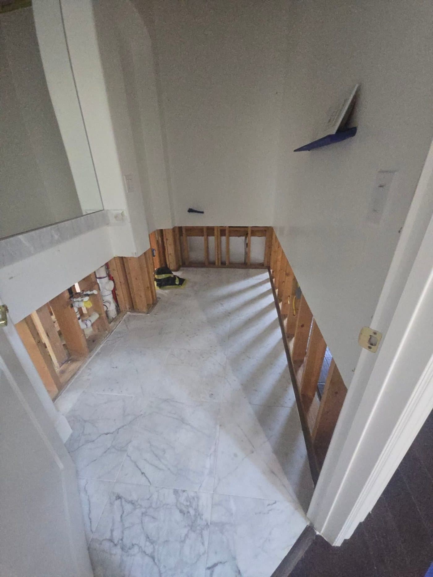 A Rhino Renovations crew hanging and finishing new drywall in a hallway.